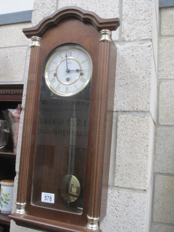 A Hermle wall clock with pendulum and key