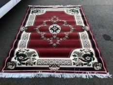 A large rug in red, green and cream,