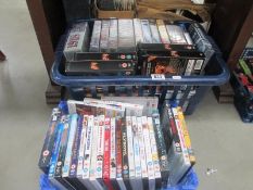 A box of dvds and a box of video cassettes which are mainly military related