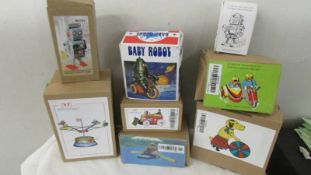 A collection of 8 boxed tin plate toys.