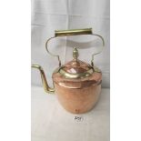 A large copper kettle with brass handle and spout.