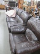 A dark brown 3 piece suite in leather with pouffe