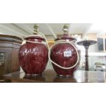 A pair of burgundy ceramic lamp base with oriental relief design.