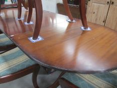 A darkwood stained oval extending dining table 91cm x 215cm,