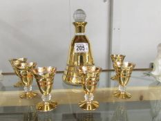 A gilded bell shaped liquor decanter and a set of 6 matching glasses.