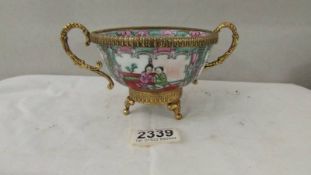 A signed famille rose bowl with gilt metal fittings.