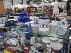 A good lot of blue and white porcelain etc on 2 shelves, such as Dutch themed lidded jars,
