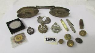 A mixed lot including 2 brass tanks, military badges, buttons, pen knives etc.