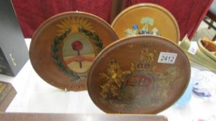 3 wooden plaques with coats of arms.