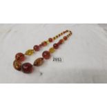 A long necklace of amber beads, reconstituted with 2 shades of amber yellow and burgundy.