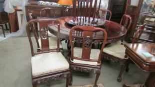 A superb quality carved circular Chinese table with revolving centre together with 8 matching