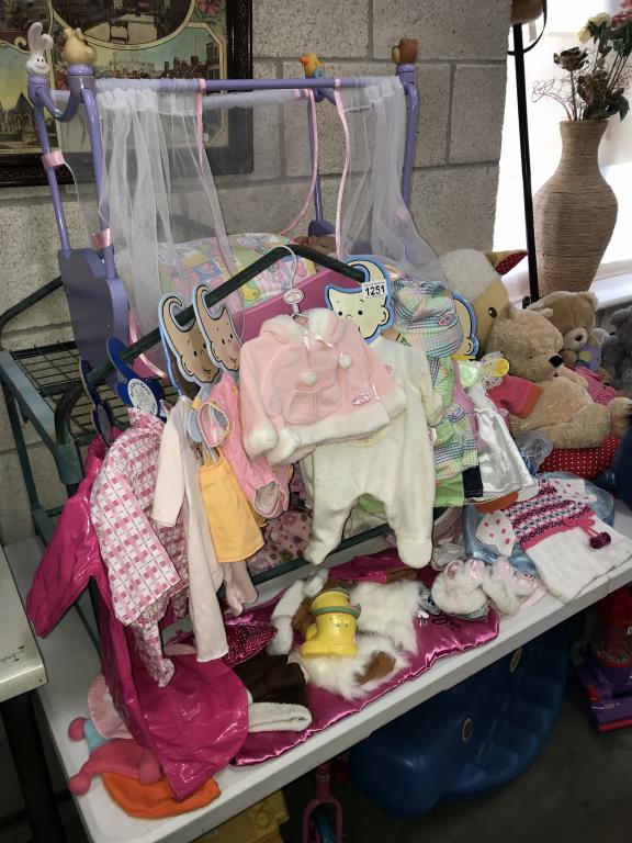 A quantity of doll's clothes & a cot with Doll