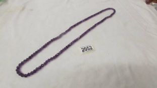 A natural amethyst stone necklace, vibrant colour, 32" long.