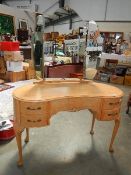 A vintage kidney shaped dressing table with triple mirror.