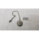 A 19th century front opening locket with chased silver front, all silver.