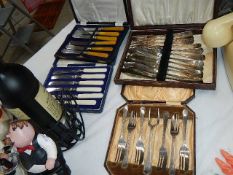 A quantity of cased cutlery sets.