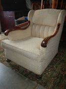 A mid 20th century elbow chair with carved arms and turned feet.