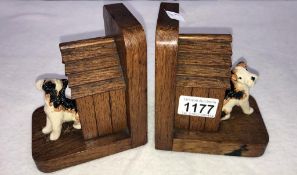 A pair of oak bookends in form of dog kennels with pottery Terrier dogs