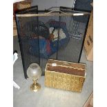 A brass candlelamp, a magazine rack and a fire guard with brass surround.