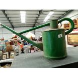 An unusually shaped green watering can