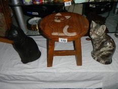 A cat stool and 2 ceramic cats.