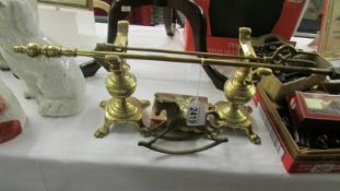 A pair of Victorian brass fire dogs, a brass poker, a brass toasting fork,