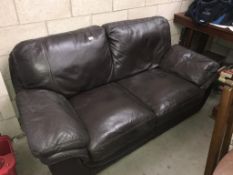 A 2 seater brown leather settee