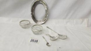 A pair of silver rimmed salts, a silver photo frame and 3 assorted silver spoons.