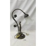 A figural swan neck table lamp with glass shade.