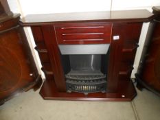 A dark wood stained electric fire surround