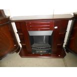 A dark wood stained electric fire surround