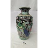 A hand painted vase decorated with birds.