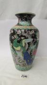 A hand painted vase decorated with birds.