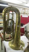 A brass tuba by Hawkes & Son., (lots of dents).