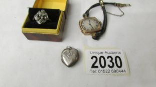 A silver heart locket, a silver ring and a ladies gold watch.