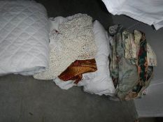 A large lot of assorted bed covers, curtains etc.