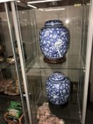 A pair of blue and white oriental lidded jars on bases, no makers marks, 29 cm high including bases.