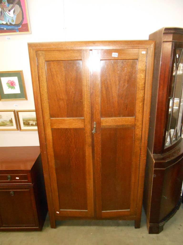 A Gentlemans oak wardrobe, half for hanging and half shelved for collars etc (no key,