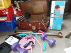 A vintage leather suitcase with weights, Pilates bands,