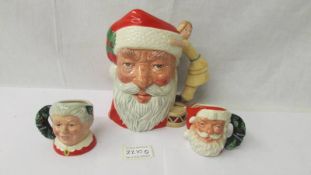 A large Royal Doulton Santa Clause D6668 together with a small Santa Clause D6900 and a small Mrs