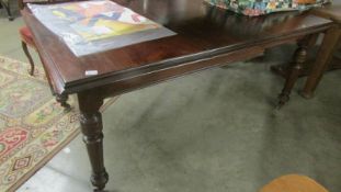 An extending mahogany dining table.