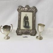 A silver photograph frame and 2 silver trophies.