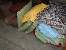 A mixed lot of cushions and blankets.