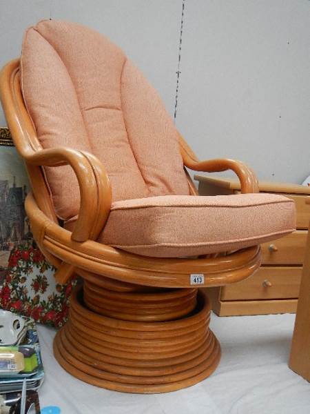A cane swivel conservatory chair.