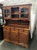 A modern solid pine dresser with glazed doors (144cm x 43cm x 185cm height)(missing cornice on top