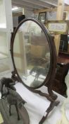 An oval mahogany toilet mirror.