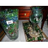 A vase and a tray of coloured glass beads.