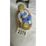 A ceramic model of Little Boy Blue asleep in the corn with hat and "horn",