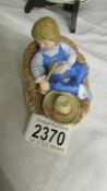 A ceramic model of Little Boy Blue asleep in the corn with hat and "horn",