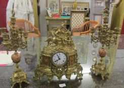 A good quality three piece brass clock garniture, the clock surmounted with horse and rider.